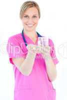 Bright female nurse holding pills and a glass water smiling at t
