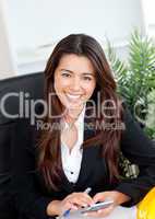 Smiling asian businesswoman using a calculator