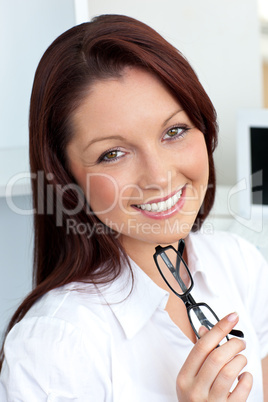 Confident businesswoman holding glasses