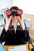 Joyful businesswoman looking through spyglasses