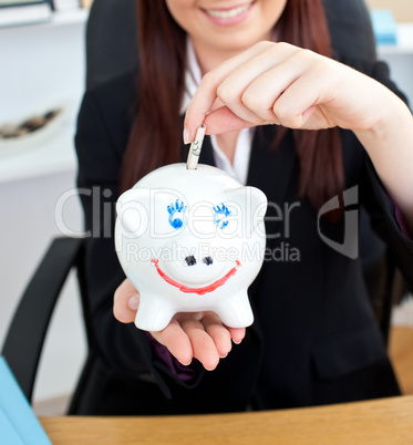 Close-up of a young businesswoman holding a piggibank