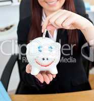 Close-up of a young businesswoman holding a piggibank
