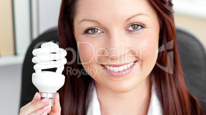 Beautiful businesswoman holding a light bulb