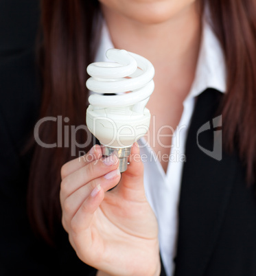 Close-up of a young businesswoman holding a light bulb