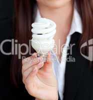 Close-up of a young businesswoman holding a light bulb