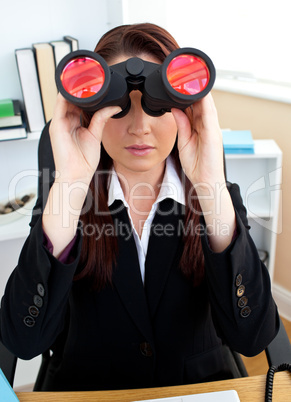 Serious businesswoman looking through spyglasses