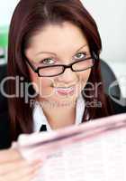 Smiling businesswoman reading a newspaper