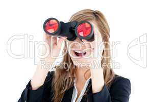 Fascinated young businesswoman looking through a spyglass