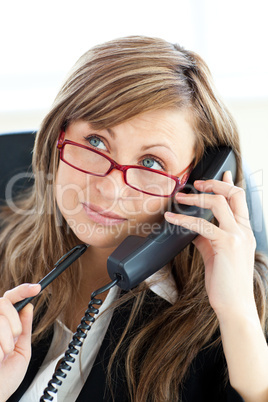 Pensive businesswoman talking on phone wearing glasses