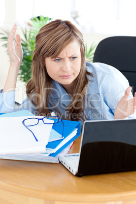 Irritated businesswoman looking at her laptop