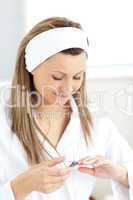 Concentrated woman using a nail scissors