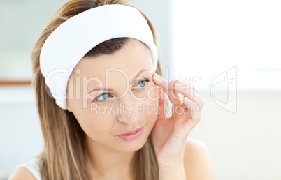 Young woman putting creme on her face