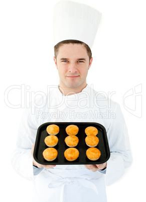 Smiling cook holding muffins in the camera
