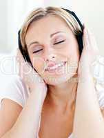 Radiant young woman listen to music wearing headphones