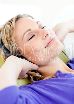 Relaxed woman listen to music lying on a sofa