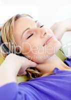 Relaxed woman listen to music lying on a sofa