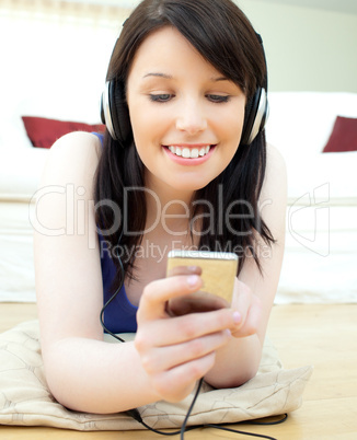Charming young woman listen to music lying on the floor