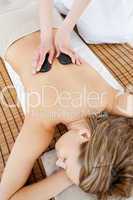 Pretty woman lying on a massage table having a stone therapy
