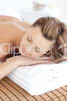 Relaxed caucasian woman lying on a massage table with closed eye