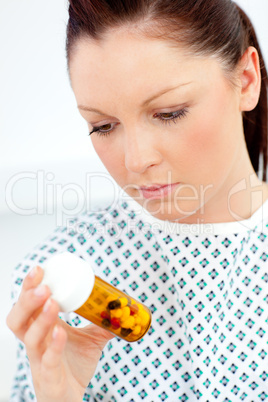 Caucasian female patient looking at pills