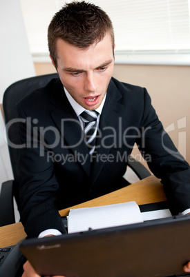 Surprised businessman looking at his laptop