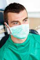 Serious male surgeon with mask and scrubs