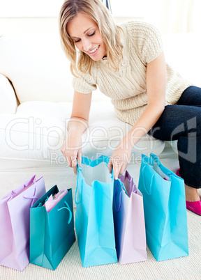 Caucasian young woman looking into her shopping bags