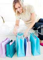 Caucasian young woman looking into her shopping bags