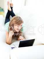 Cheerful caucasian woman looking at her laptop on the sofa