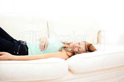 Caucasian blond woman lying on a sofa relaxing