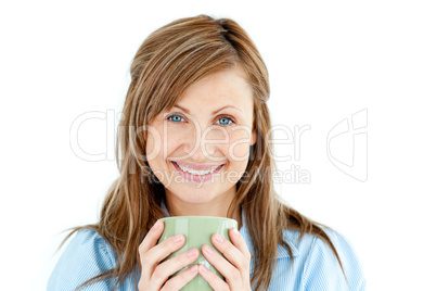 Cute woman holding a cup of coffee smiling at the camera