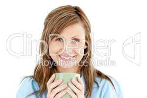 Cute woman holding a cup of coffee smiling at the camera