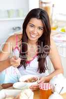 Smiling asian woman eating muesli with fruits