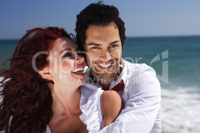 young couple enjoying on the beach laughing