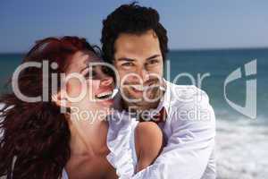 young couple enjoying on the beach laughing