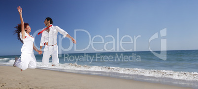 Young Couple at the beach jumping for joy