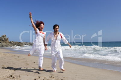 Young Couple at the beach jumping for joy holding hands