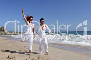 Young Couple at the beach jumping for joy holding hands