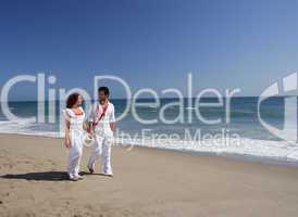 Young Couple at the beach walking while holding hands