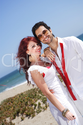 young couple at the beach smiling and posing