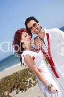 young couple at the beach smiling and posing