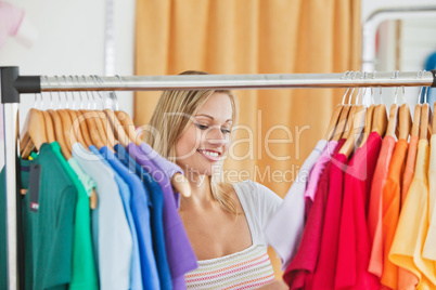 Cute young woman holding a colorful shirt