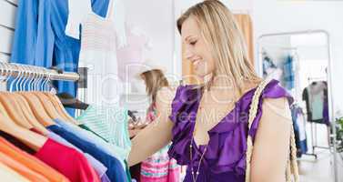 Elegant young woman choosing clothes with her friend