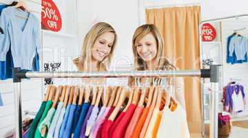 Joyful female friends choosing colorful shirts