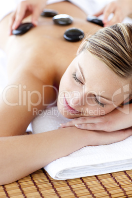 Glad woman receiving a massage with hot stone
