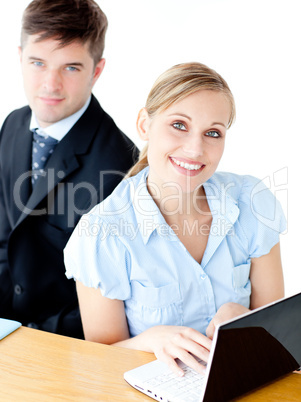 Attractive couple of businesspeople using their laptop at the ta