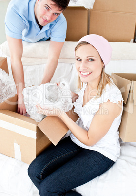 Animated young couple packing a box