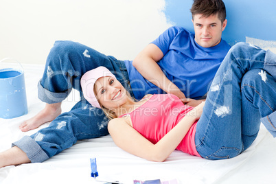 Cute couple relaxing after paiting a room