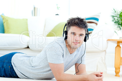 Handsome man with headphones lying on the floor