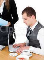 Charming businesswoman standing near the table while her husband